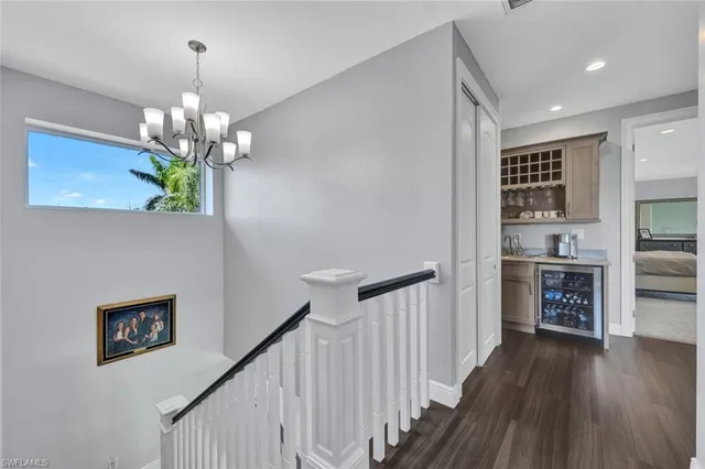 a view of a hallway with wooden floor and a kitchen