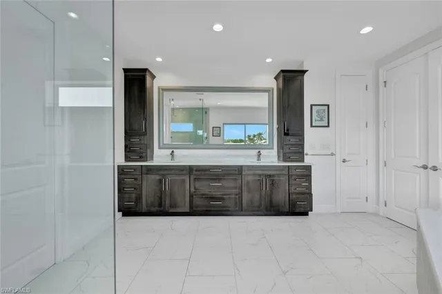 a large bathroom with a large mirror vanity and shower