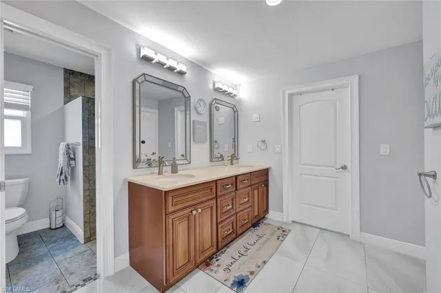 a bathroom with a double vanity sink mirror and toilet