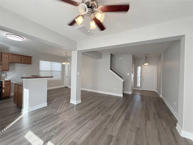 a view of a kitchen with wooden floor and a ceiling fan