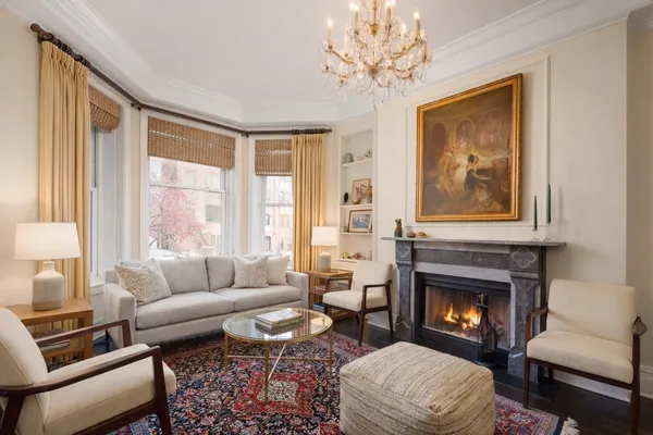 a living room with furniture a fireplace and a large window