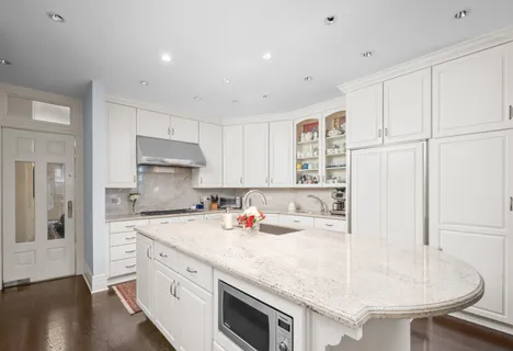 a kitchen with a sink a stove a refrigerator and white cabinets