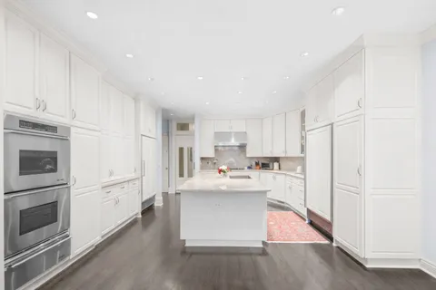 a kitchen with stainless steel appliances granite countertop a refrigerator sink and white cabinets