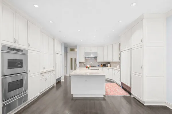 a kitchen with stainless steel appliances granite countertop a refrigerator sink and white cabinets