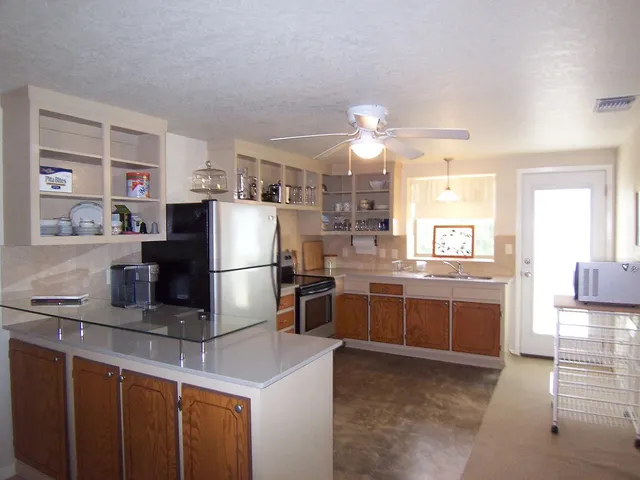 a kitchen with stainless steel appliances granite countertop a sink stove and refrigerator
