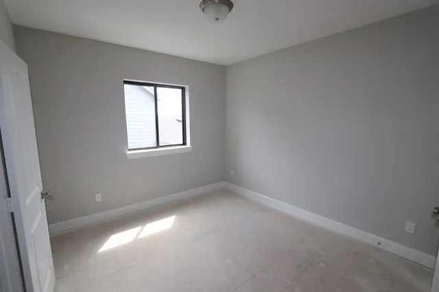 a view of an empty room with a fireplace and a window