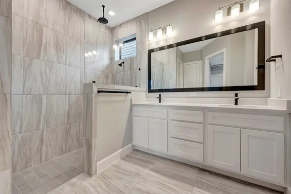 a bathroom with a sink double vanity and a mirror