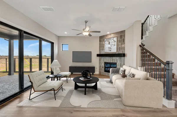 a living room with furniture a fireplace and a large window
