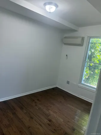 a view of a small space with wooden floor and a window