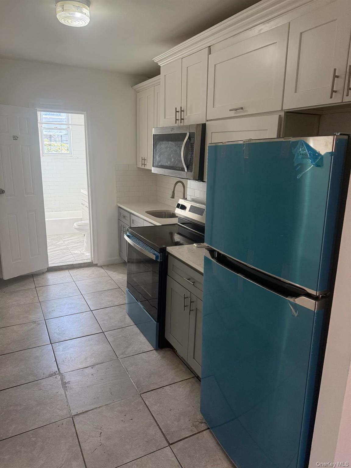 2280 Atlantic Avenue, Unit 1 Brooklyn, NY 11233 - Photo 3 of 5 a kitchen with stainless steel appliances granite countertop a refrigerator and a stove