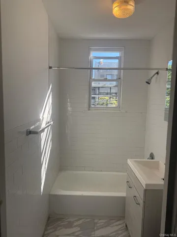 a bathroom with a tub a sink and a shower