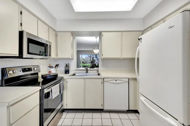 a kitchen with white cabinets and white appliances