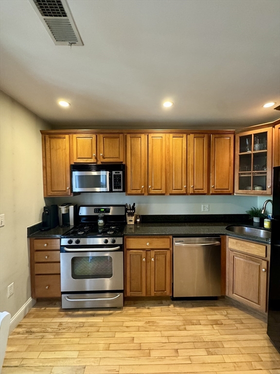 a kitchen with stainless steel appliances a stove sink and microwave
