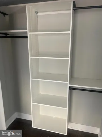 a view of walk in closet with empty racks