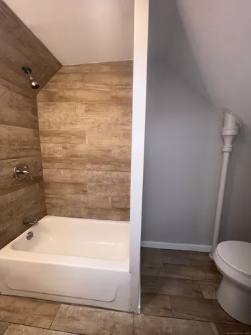 a bathroom with a bathtub and a toilet