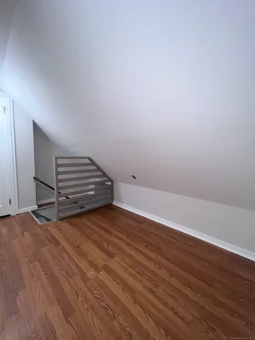 a view of room with wooden floor and white walls