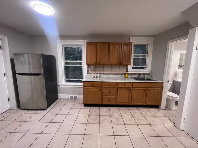 a kitchen with a refrigerator a stove top oven and a window
