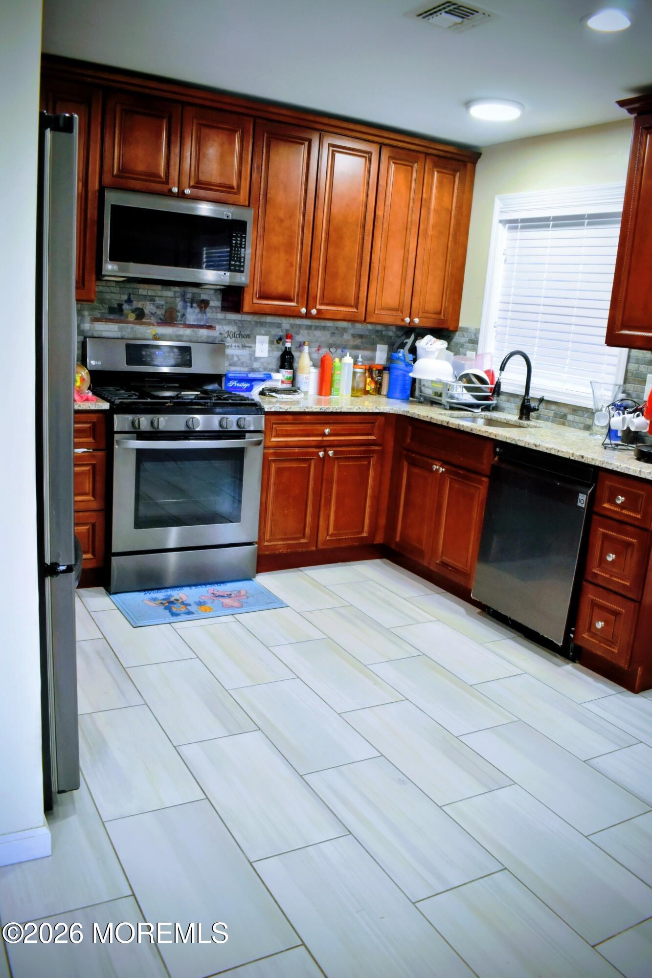 151 1st Street Keyport, NJ 07735 - Photo 5 of 24 a kitchen with stainless steel appliances a stove sink microwave and cabinets