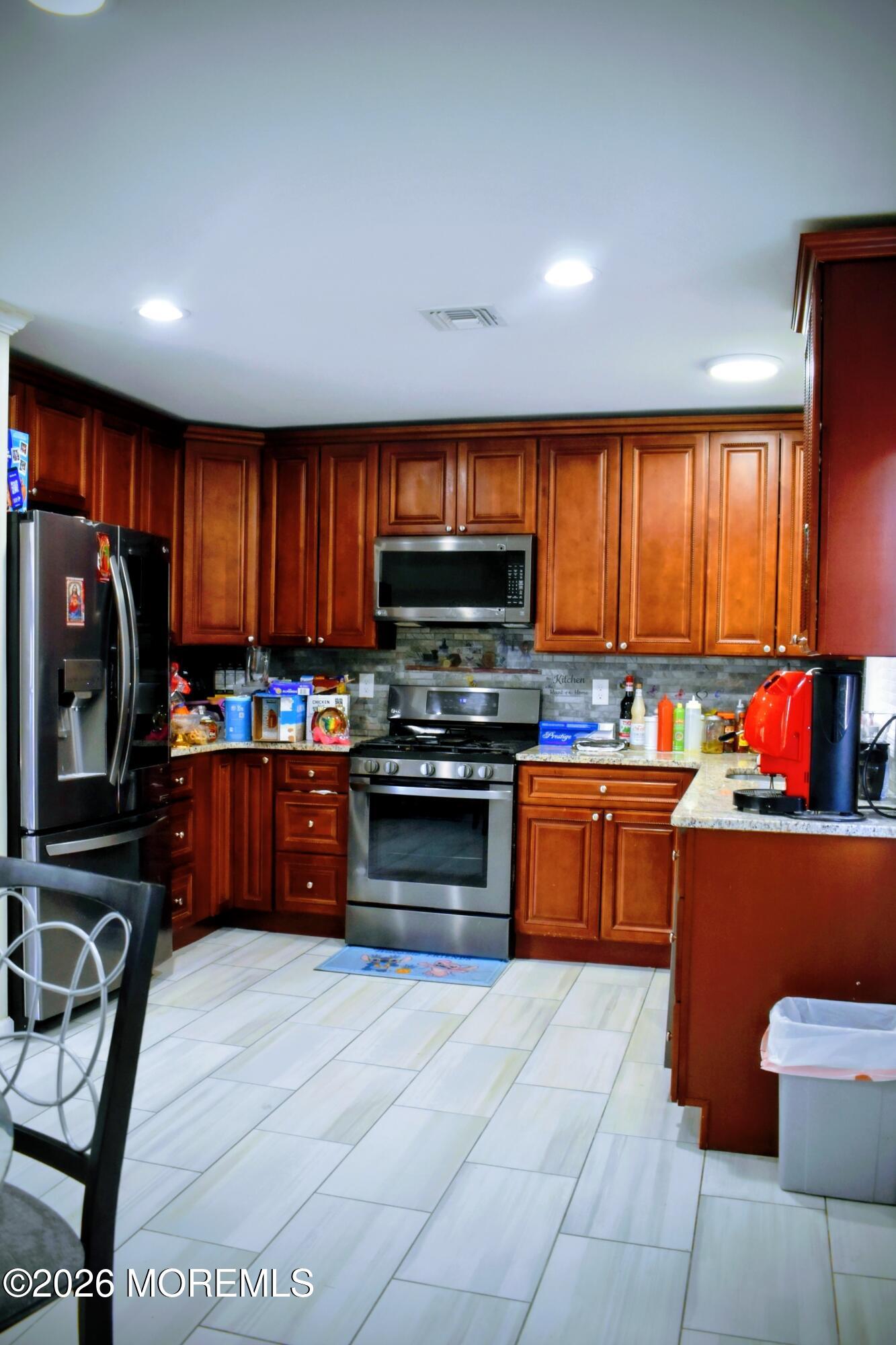 151 1st Street Keyport, NJ 07735 - Photo 8 of 24 a kitchen with stainless steel appliances wooden cabinets a stove top oven a sink and a refrigerator