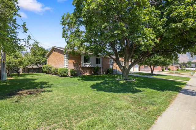 358 West 1200th Street North Mapleton, UT 84664 - Photo 2 of 30 Brick exterior with white decorative stone accents and multiple mature trees