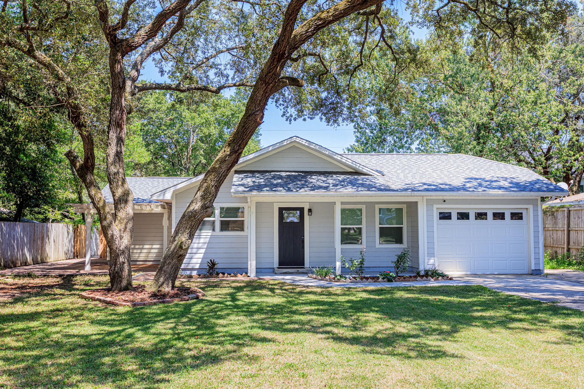 1013 Gloria Avenue Fort Walton Beach, FL 32547 - Photo 2 of 31 a front view of a house with a garden