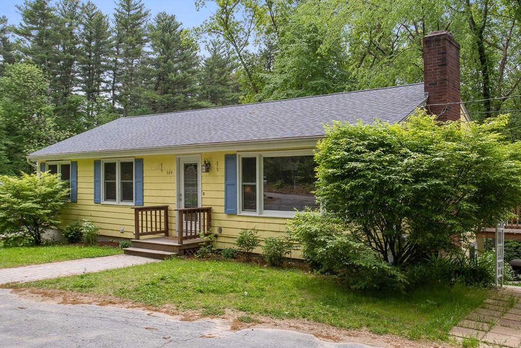 a front view of a house with a garden and yard