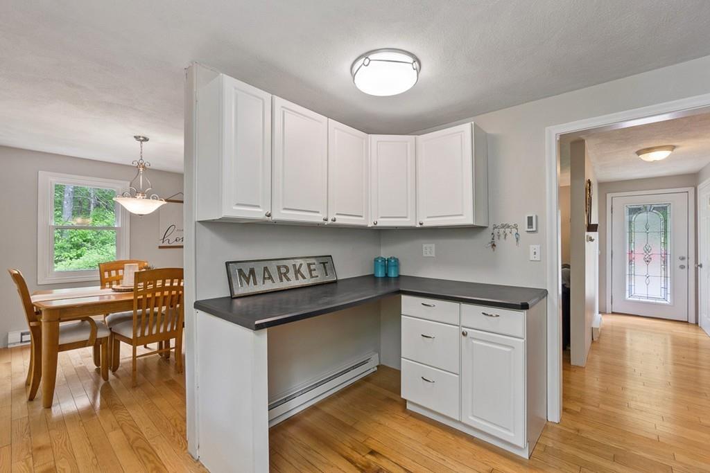 684 Burroughs Road Boxborough, MA 01719 - Photo 12 of 30 a kitchen with granite countertop a stove a sink and white cabinets with wooden floor