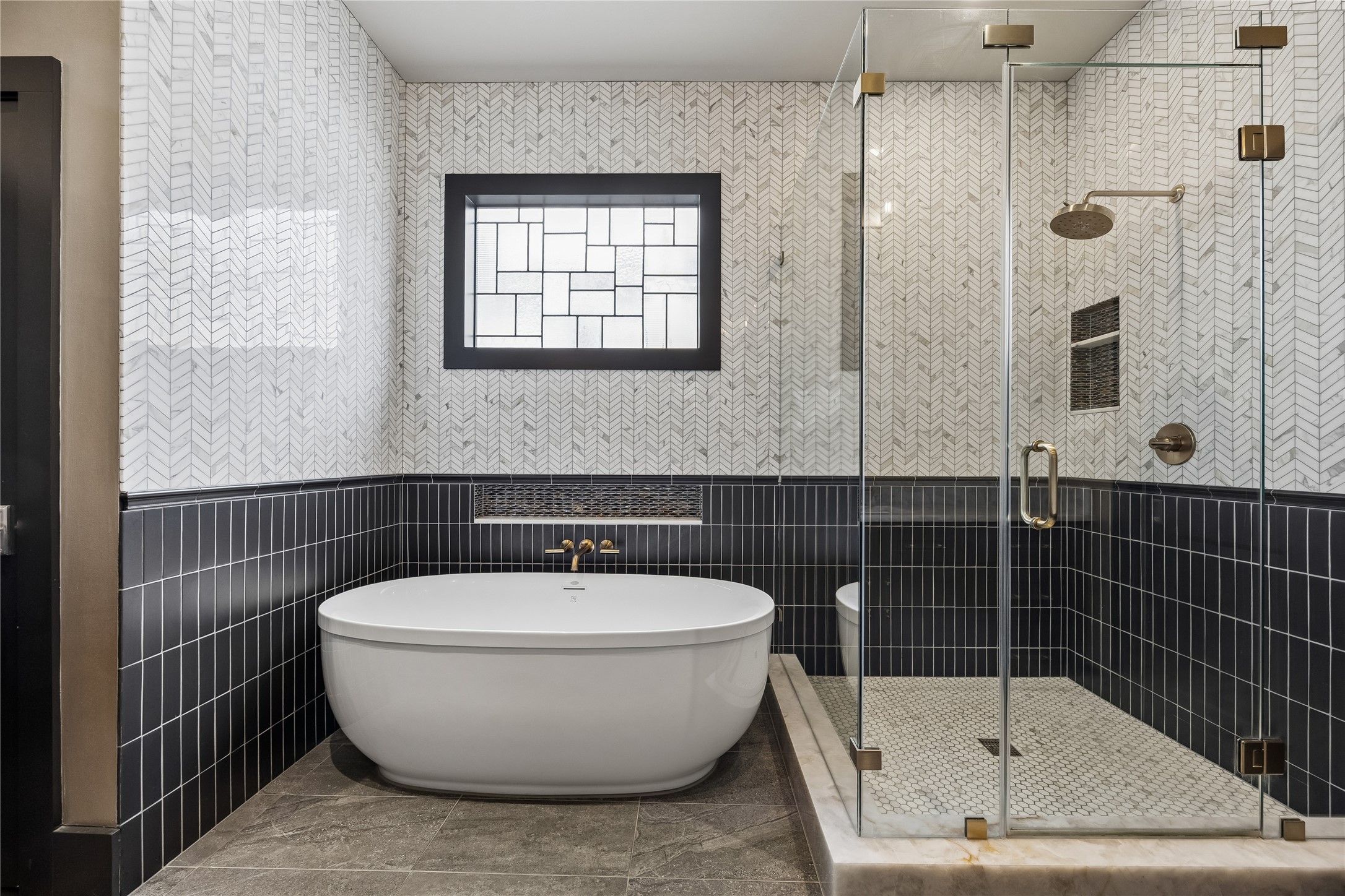 926 Nicholson Street Houston, TX 77008 - Photo 22 of 39 The renovated primary bath pairs timeless marble finishes with a freestanding soaking tub and oversized walk-in shower.