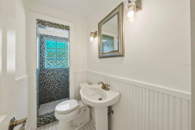 a bathroom with a sink toilet and a mirror