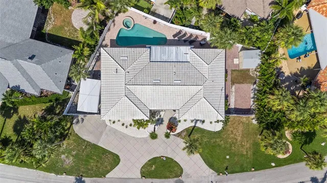 a view of a house with a yard and palm trees
