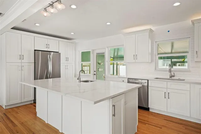 a kitchen with stainless steel appliances granite countertop a sink stove and refrigerator