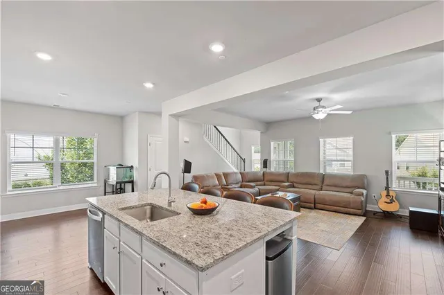 a open kitchen with stainless steel appliances granite countertop a sink a stove and a wooden floors