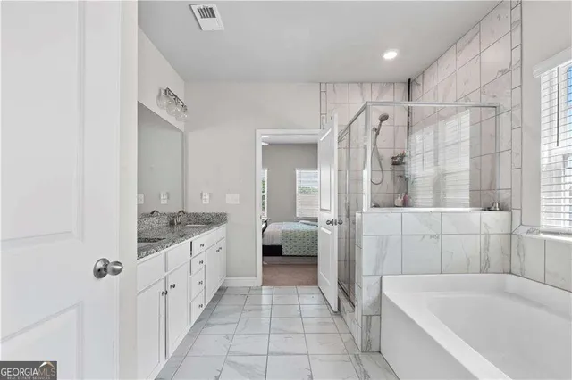 a bathroom with a granite countertop sink vanity mirror and toilet