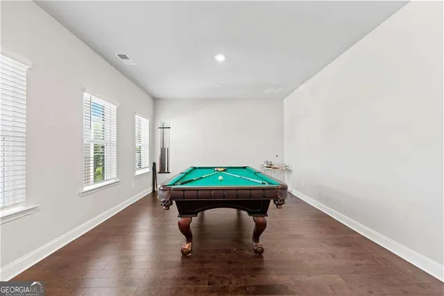 a room with furniture pool table and wooden floor
