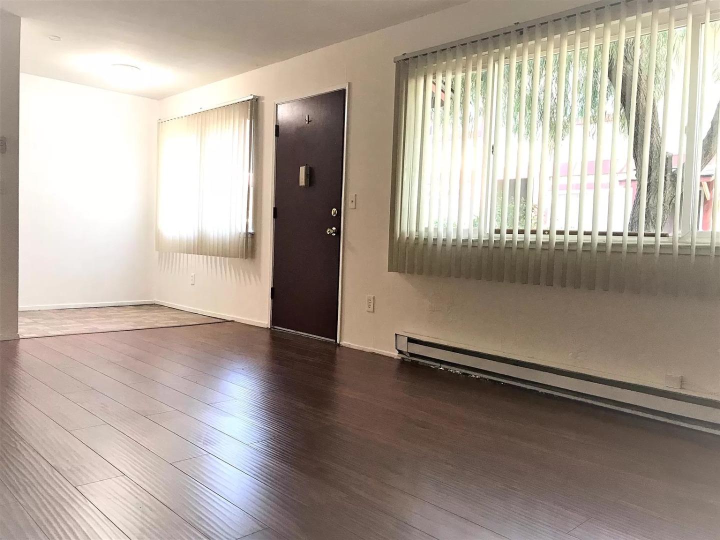 195 East Reed Street, Unit 4 San Jose, CA 95112 - Photo 3 of 11 an empty room with wooden floor and windows