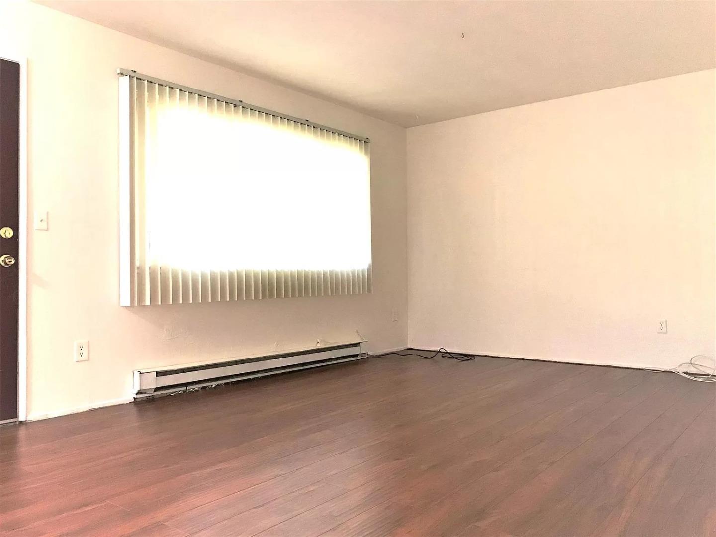 195 East Reed Street, Unit 4 San Jose, CA 95112 - Photo 4 of 11 a view of an empty room with wooden floor and a window