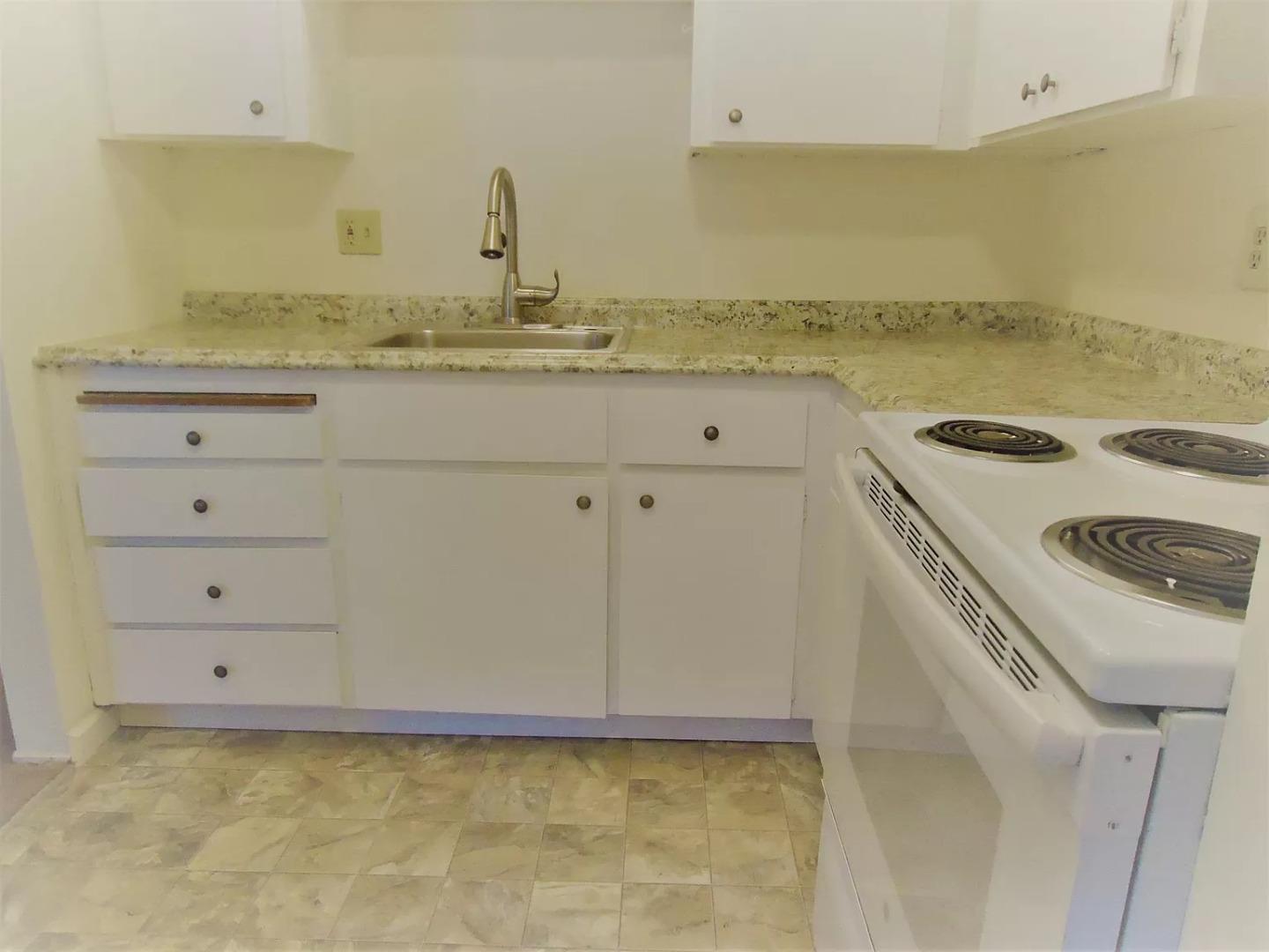 195 East Reed Street, Unit 4 San Jose, CA 95112 - Photo 6 of 11 a kitchen with granite countertop a sink a stove and cabinets