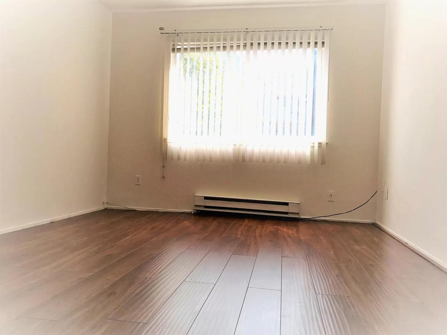195 East Reed Street, Unit 4 San Jose, CA 95112 - Photo 7 of 11 an empty room with wooden floor and windows