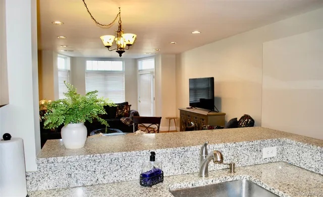 a kitchen with stainless steel appliances granite countertop a sink refrigerator and microwave