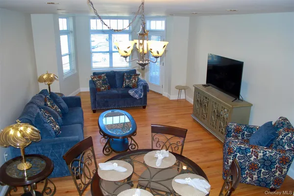 a living room with furniture a chandelier and a flat screen tv