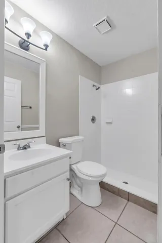 a bathroom with a toilet sink a mirror and shower