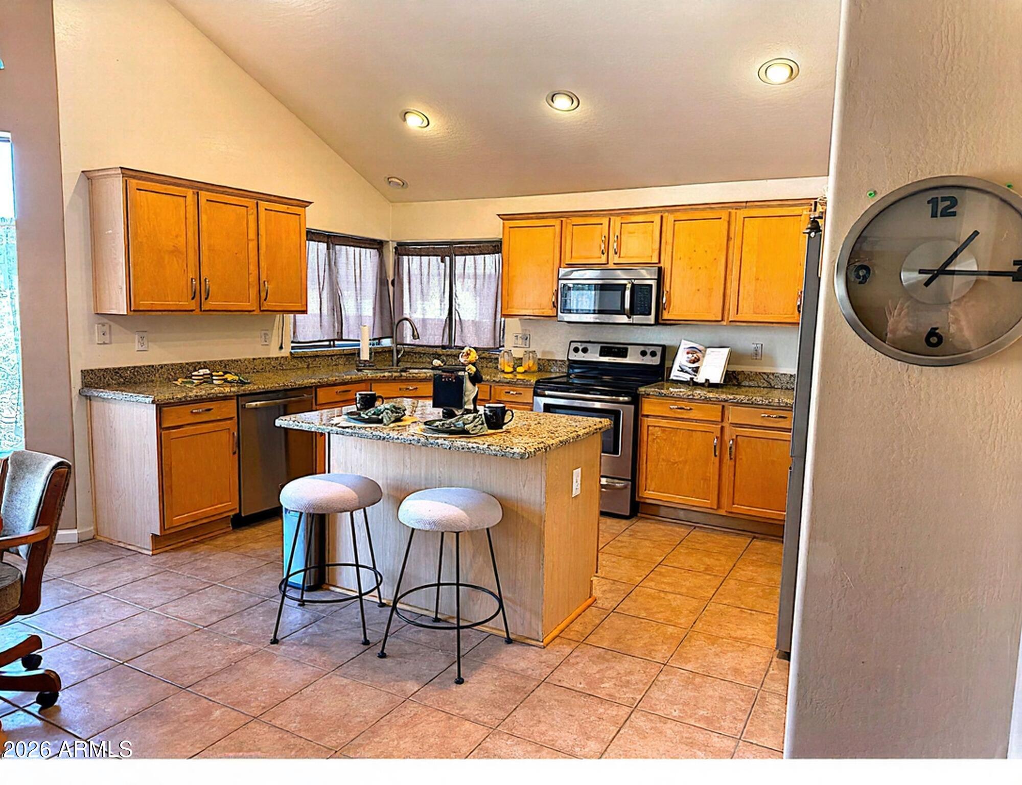 11058 East Cholla Road Mesa, AZ 85207 - Photo 3 of 22 a kitchen with stainless steel appliances granite countertop a stove a sink a microwave a refrigerator and cabinets