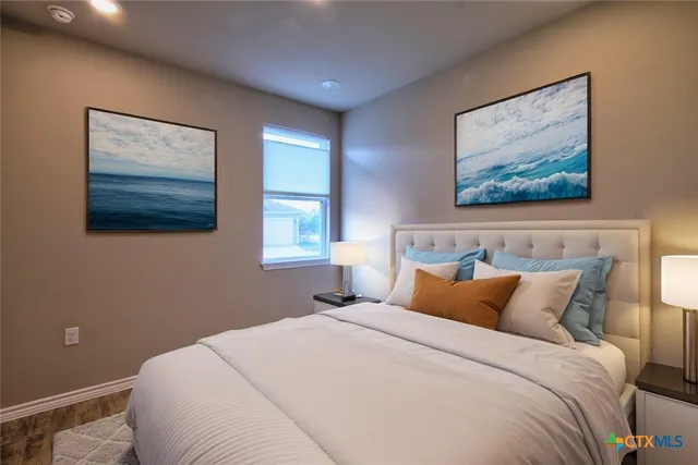 a bedroom with a bed and a painting on the wall