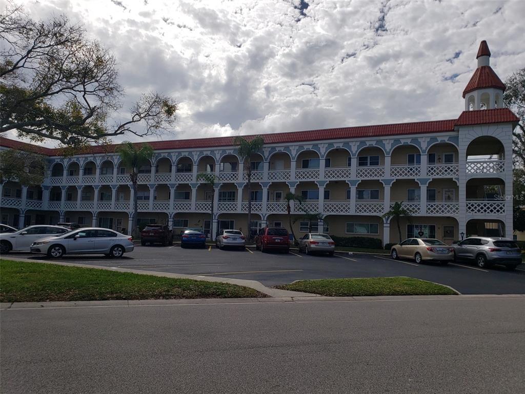 a front view of a building with cars parked