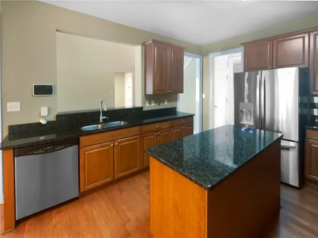 a kitchen with granite countertop a sink a counter top space and cabinets