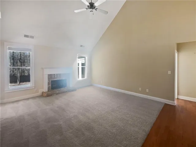 an empty room with windows and fireplace