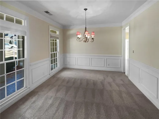 a view of empty room with windows and chandelier