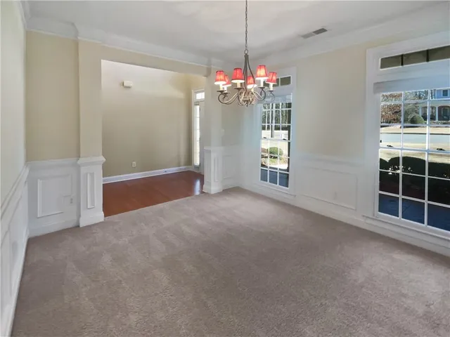 a view of a big room with windows and chandelier