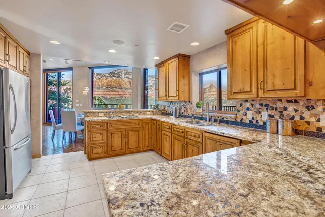 a large kitchen with kitchen island granite countertop a large window and stainless steel appliances