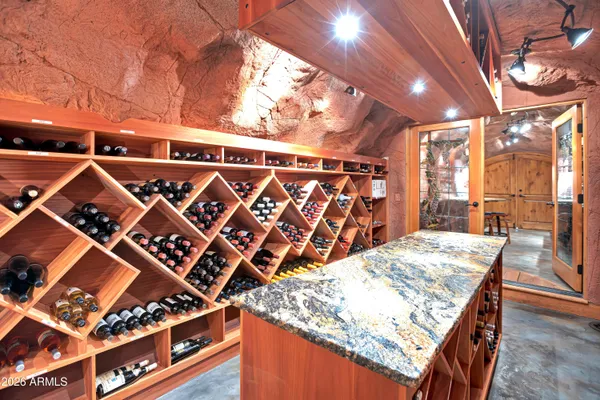 a spacious bedroom with a bed a couch and a chandelier